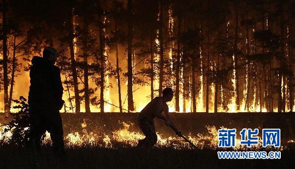 8月4日，两名男子在俄罗斯多尔吉尼诺村附近灭火。 新华社/法新