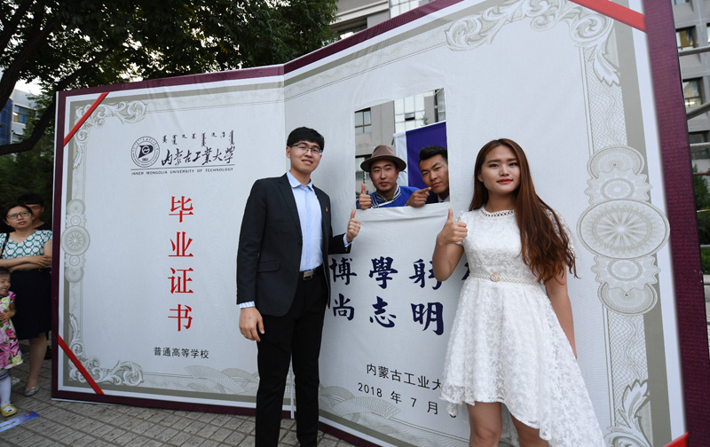 6月22日，毕业生在巨大的“毕业证书”旁合影。当日，内蒙古工业大学