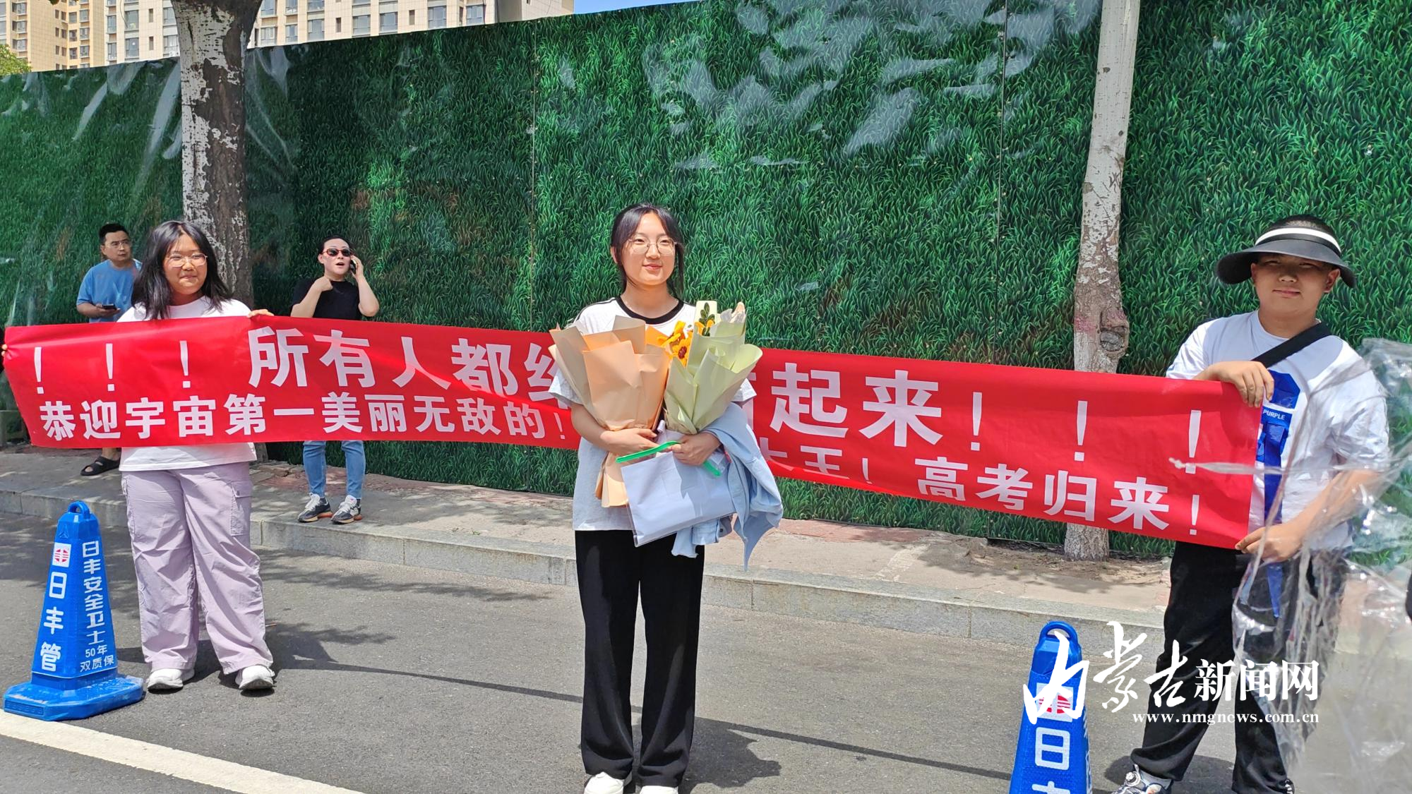 付宇晶(右二)手持鲜花在横幅前与家人合影 IMG_20250607_155444.jpg
