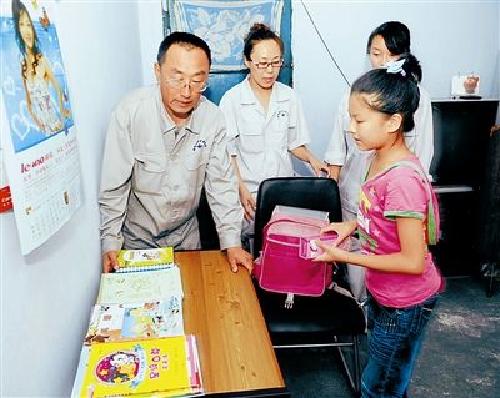 郭明义给资助的学生送去新课桌 李 钢摄