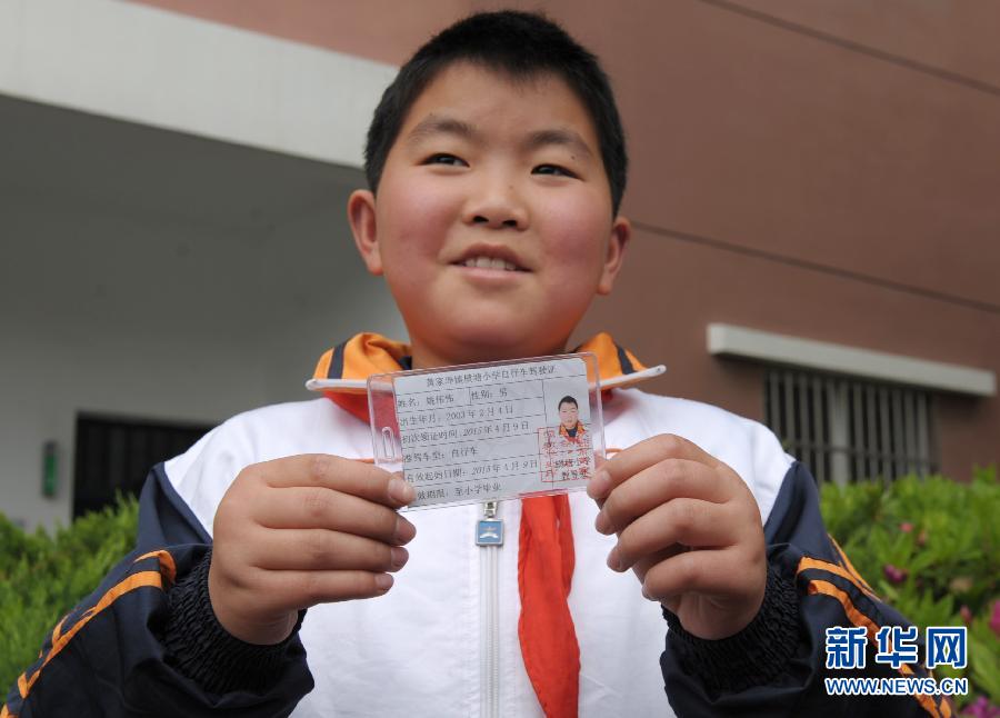 4月9日,浙江省余姚市黄家埠镇横塘小学的学生展示他获得的自行车"驾照