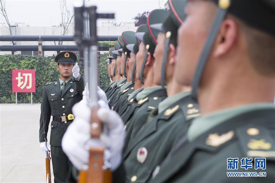 7月29日,中國人民解放軍陸海空三軍儀仗隊教官(左)在駐地指導隊員訓練