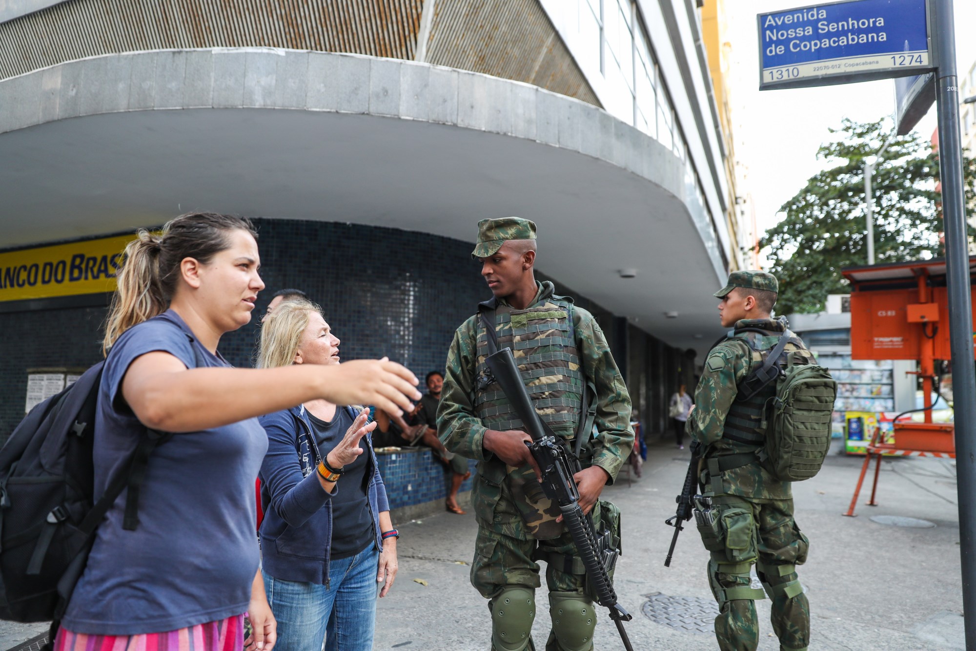 7月29日,安保人员在巴西里约热内卢科帕卡巴纳海滩附近街区为游客指路