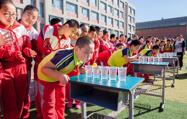 内蒙古呼和浩特市玉泉区通顺街小学学生在参加"吹乒乓球"趣味游戏