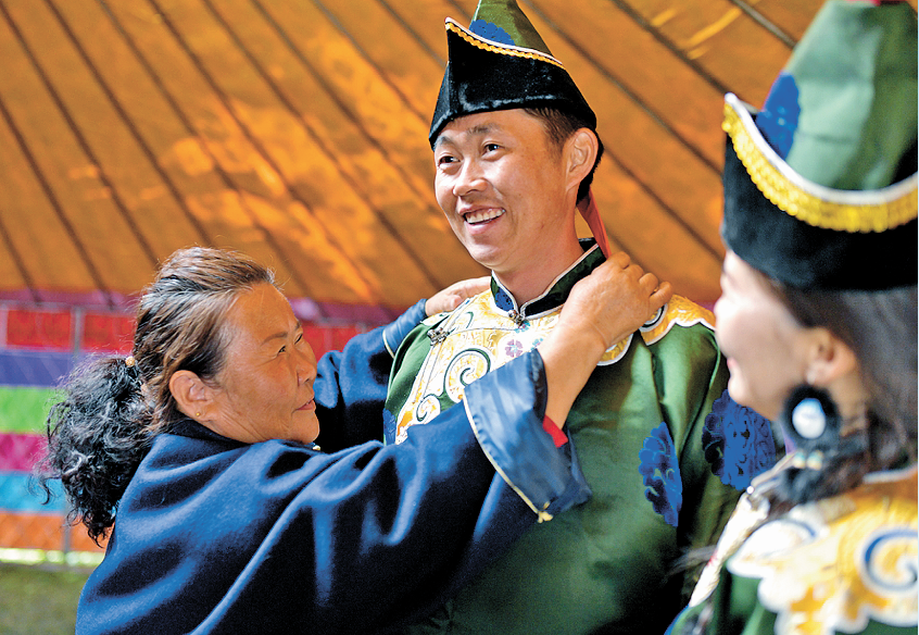 为女婿试穿亲手缝制的民族服装