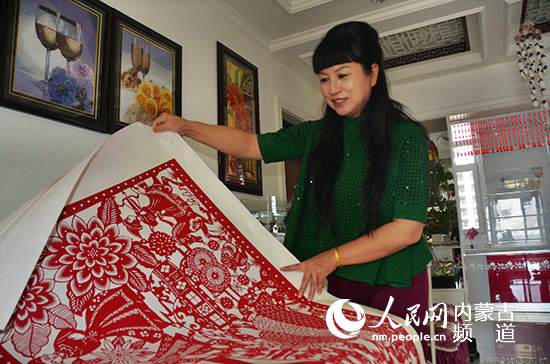 钱秀云向记者展示她的剪纸作品钱秀云的女儿看到母亲这么拼命,很是
