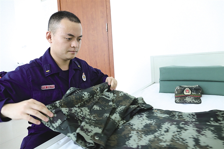 李磊小心地将橄榄绿军装叠放好