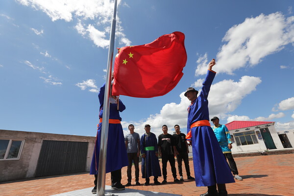 飘着五星红旗的一家牧户格外引人注目,这是"党员中心户"白那木吉拉家